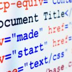 HTML source code of web page with document title, metadata description and links monitor screenshot diagonal view, small depth of sharpness